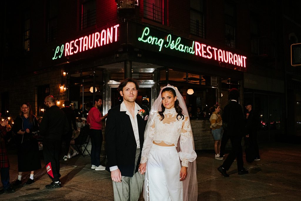 Couple poses in front of Long Island Restaurant after eloping in NYC.