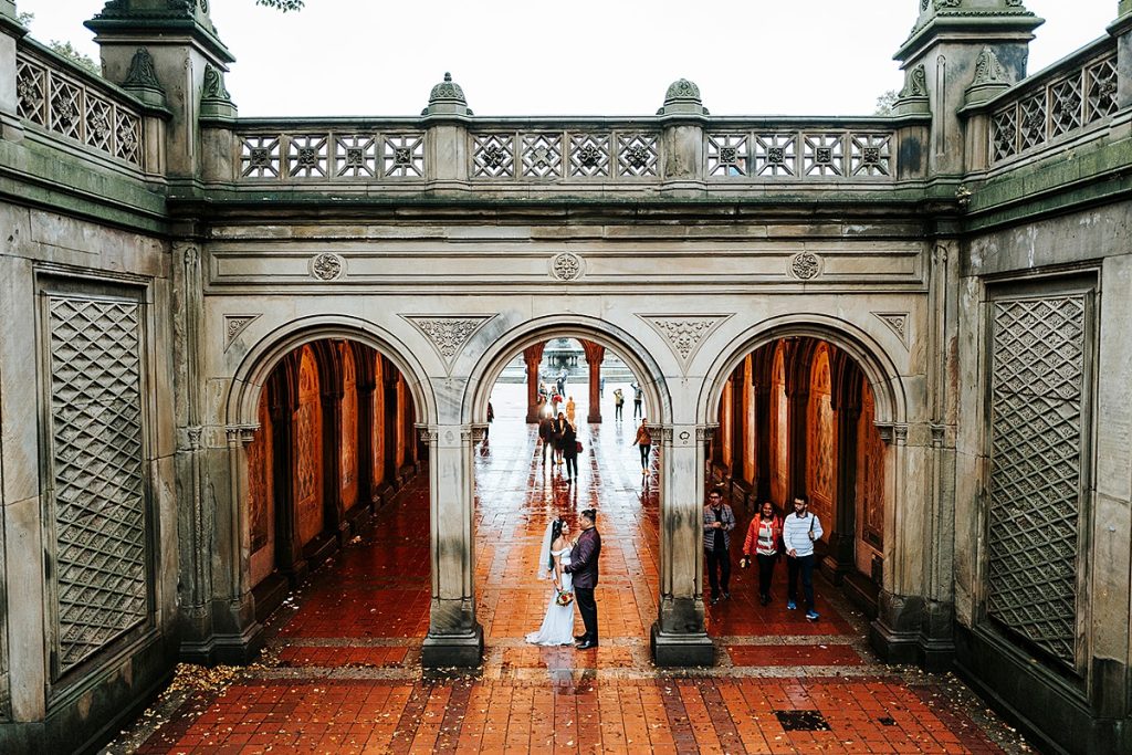 Couple elopes in Bethesda Terrace and Arcade in Central Park, NYC. It’s one of the most popular and romantic elopement spots, with its arches, tiled ceiling, and views of Bethesda Fountain.