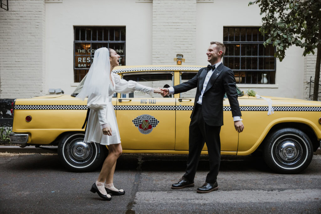 Couple standing in front of vintage taxi after NYC elopement
