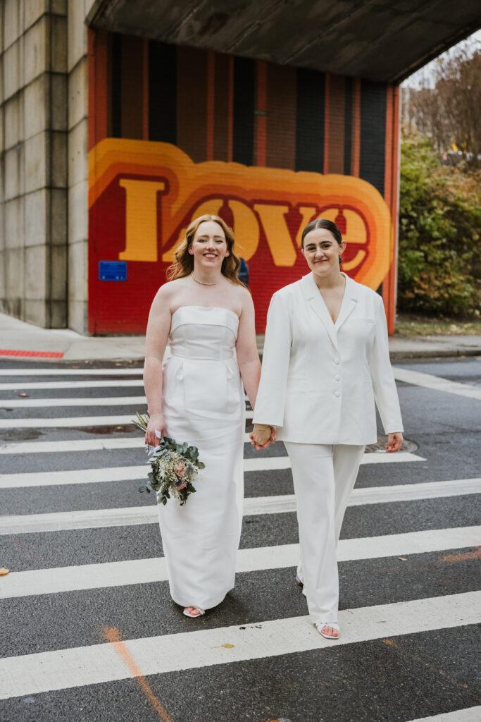 NYC elopement brides wear stunning white dress and white suit with matching large bows on the back.