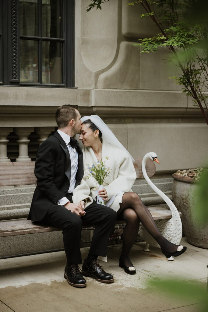 Newlywed couple sits on the bench at Nine Orchard Hotel in New York City.